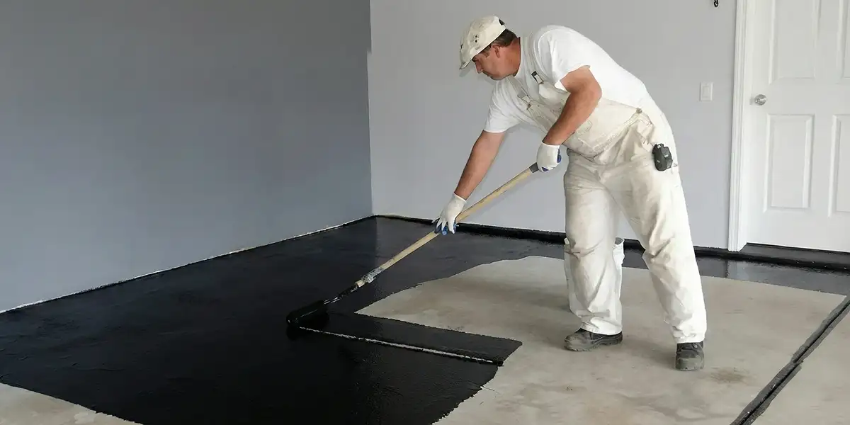 basement waterproofing professional applying waterproof coating to protect a basement floor in Wichita, KS