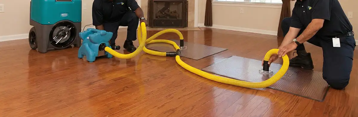 emergency water removal technicians extracting standing water from a home using professional equipment in Wichita, KS